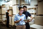 Woman and man in warehouse looking at tablet